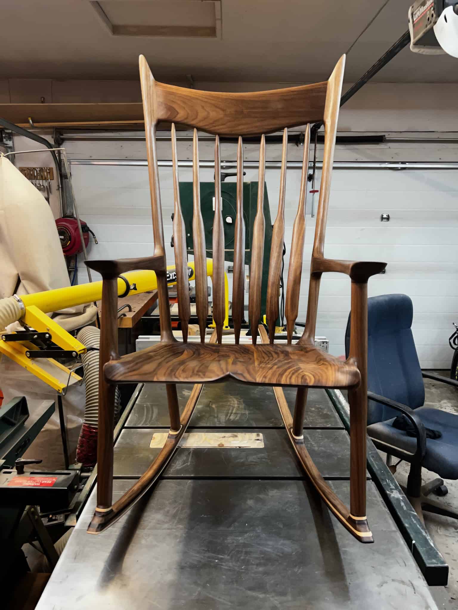 Front view in the shop: sculpted seat, shaped spindles and the flared crest rail.