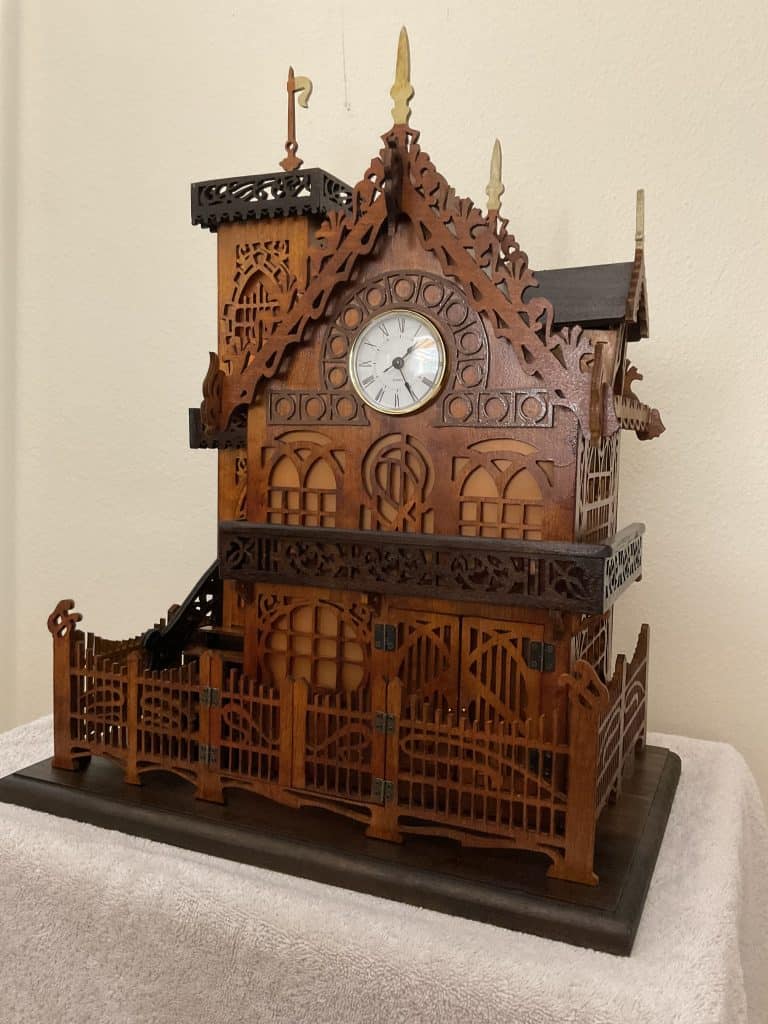 The same clock photographed with the lights off, which shows the dye-stained cherry, beech and maple and the darker roof and base.
