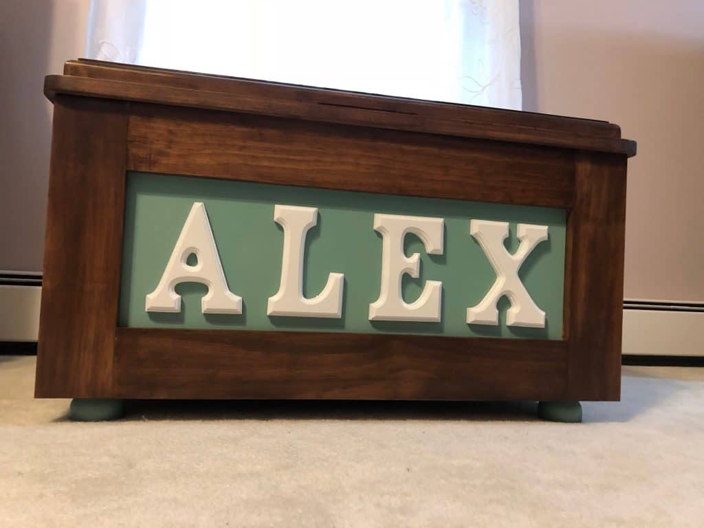 One of the two stained select-pine boxes, with a green panel, "ALEX" in cream letters and green-painted feet.