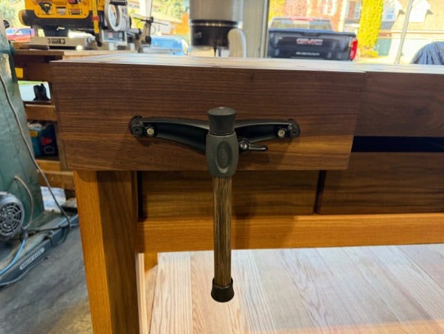 The quick-release vise mounted under the walnut edging.