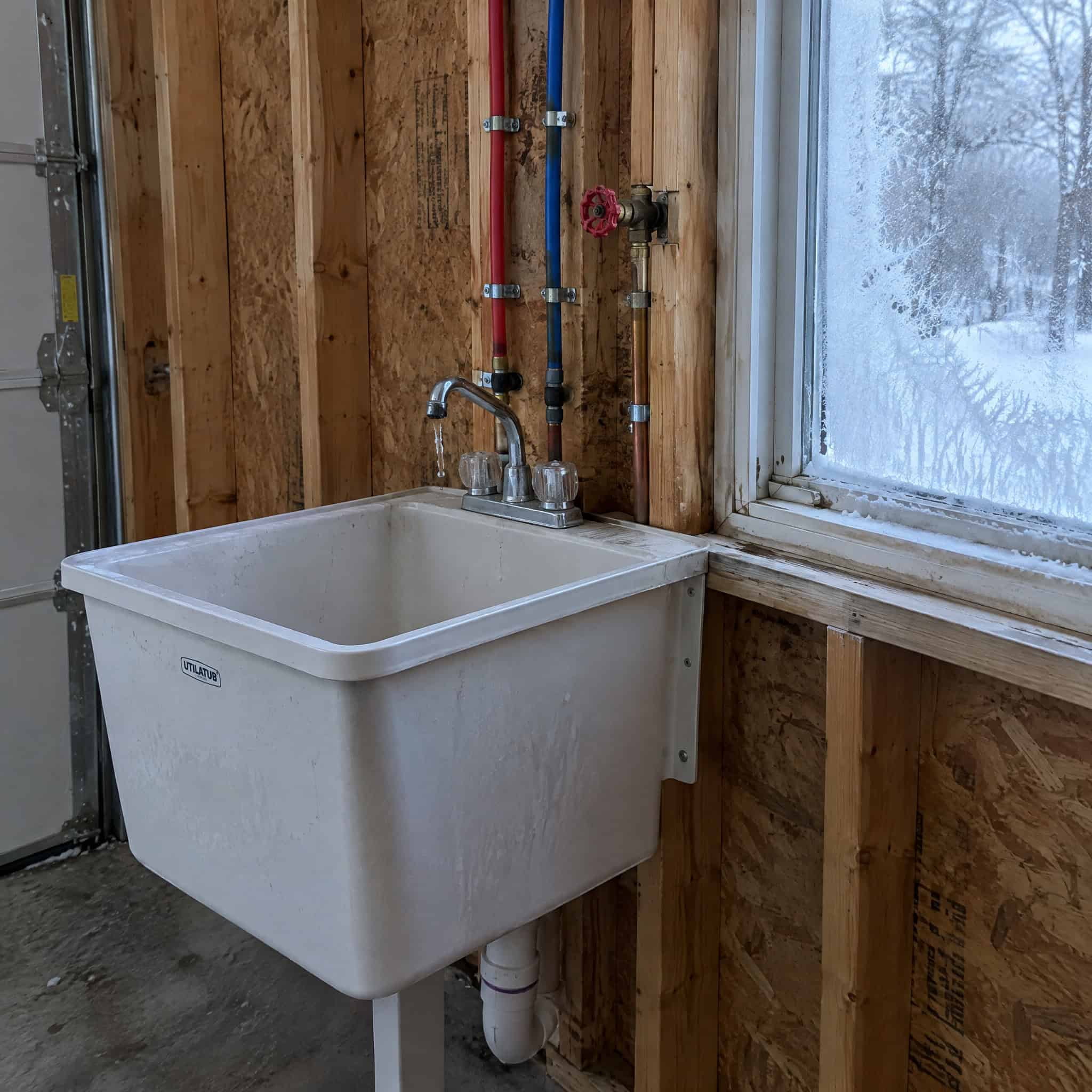 A utility sink plumbed into an unheated garage wall