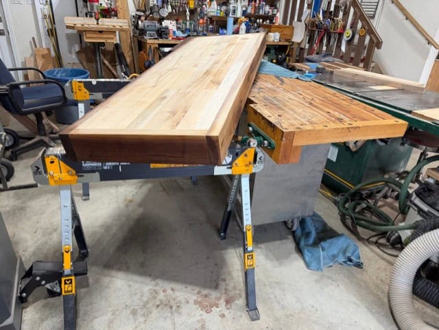 Moving the new top off the old bench onto sawhorses — a one-man job.
