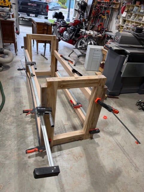 The 'fun part' — clamping the stretchers to the legs with long bar clamps.