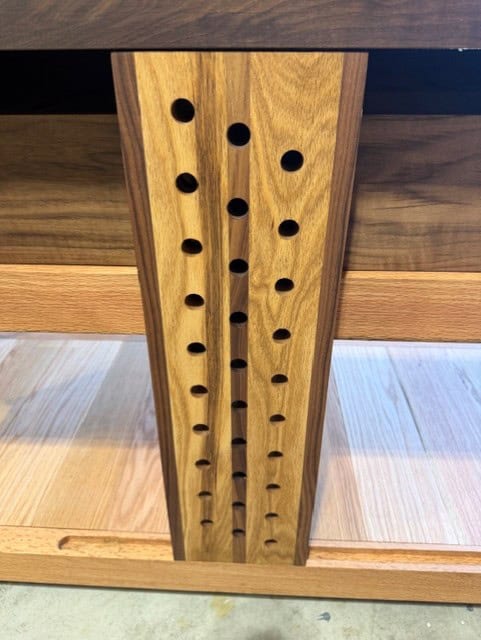 The sliding deadman, with its staggered rows of holes and walnut edges.