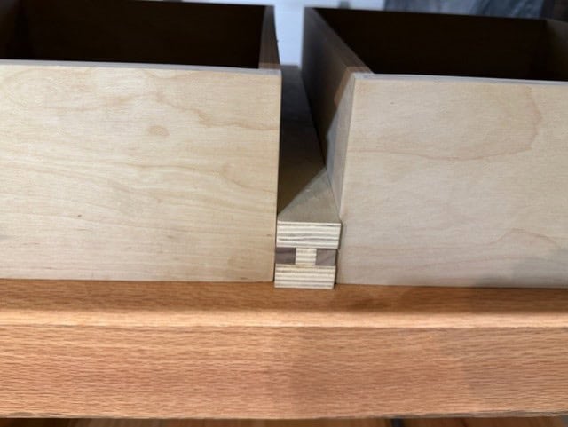 Shop-made plywood runners with hardwood sliders between the drawers.