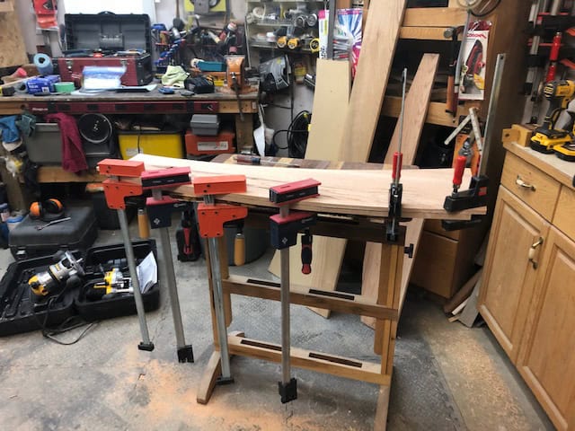 A bullnose glued and clamped onto the front edge of an oak tread in the shop.