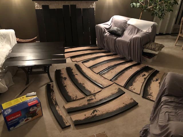 Curved treads spread across the living room floor during staining.
